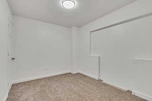 Spare room with light carpet and baseboards