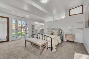 Bedroom featuring beam ceiling, light colored carpet, and access to exterior