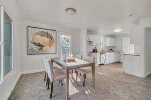 Dining space featuring light carpet and baseboards