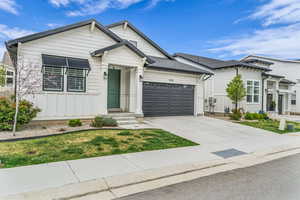 View of front of house with board and batten siding, concrete driveway, and an attached garage