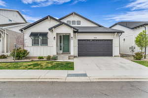 View of front facade featuring concrete driveway, an attached garage, and a shingled roof