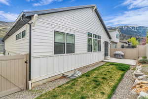 View of property exterior featuring a mountain view, a patio, a gate, and board and batten siding