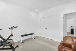 Workout room with light colored carpet and recessed lighting