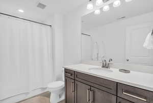 Bathroom featuring vanity, recessed lighting, and shower / bathtub combination with curtain