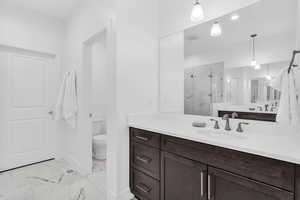 Full bath with a marble finish shower, vanity, and light marble finish floors