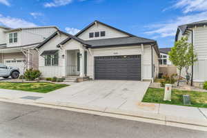 View of front of home featuring roof with shingles, driveway, and board and batten siding