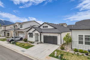 View of front of property featuring roof with shingles, concrete driveway, a residential view, board and batten siding, and a mountain view