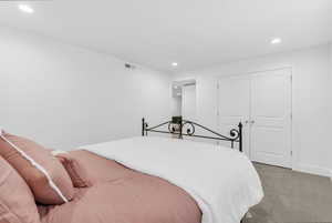 Bedroom with recessed lighting, carpet flooring, and a closet