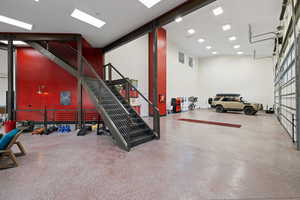Exercise room with a high ceiling and a garage