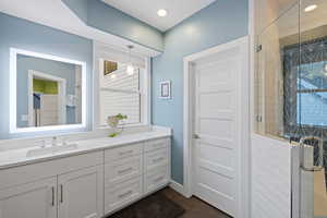 Full bathroom featuring a stall shower, vanity, dark tile patterned floors, and recessed lighting