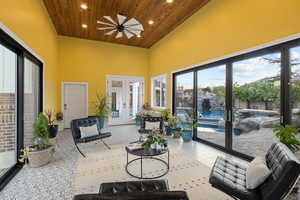 Sunroom with french doors, a high wooden ceiling, and recessed lighting