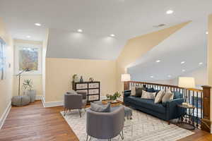 Living area with recessed lighting, light wood-style floors, and vaulted ceiling