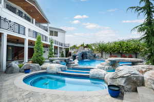 Combined pool / hot tub with a balcony and a patio area