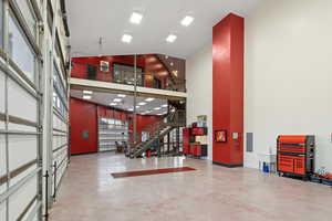 Garage featuring electric panel and baseboards