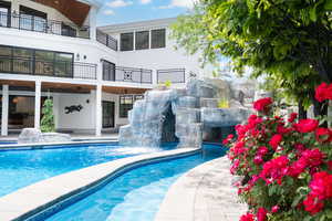 Outdoor pool with a patio and a balcony