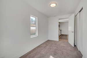 Unfurnished bedroom featuring light colored carpet and a closet