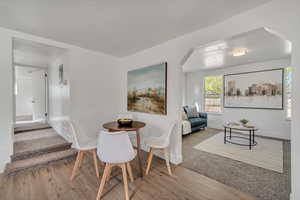 Dining area with light wood-style flooring and arched walkways