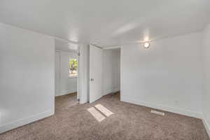 Unfurnished bedroom with baseboards and light carpet