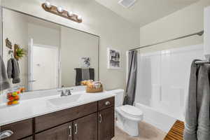 Full bathroom featuring vanity, shower / bathtub combination with curtain, and light tile patterned floors