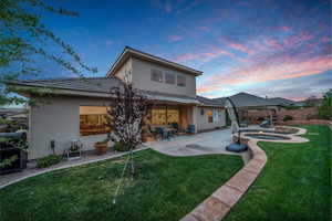 Rear view of house with stucco siding, an in-ground hot tub, a patio, and ceiling fan