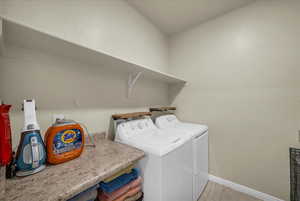 Laundry room with washer and clothes dryer and light tile patterned floors