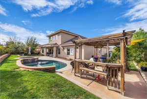 Rear view of house featuring outdoor dining space, a patio, a pool with connected hot tub, and a lawn