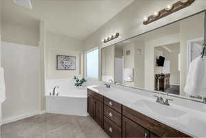 Full bath with double vanity, a bath, light tile patterned floors, and a walk in shower