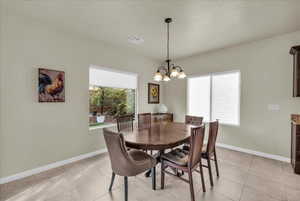 Dining area with hanging lights and light tile patterned floors