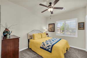 Bedroom with dark colored carpet and ceiling fan