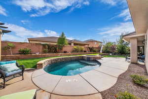 Integrated pool / hot tub featuring a patio and a fenced backyard