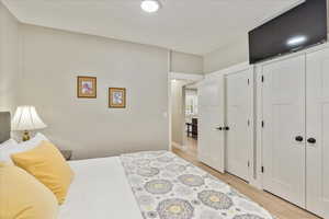 Bedroom with light wood finished floors and a closet