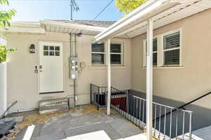 Doorway to property featuring stucco siding