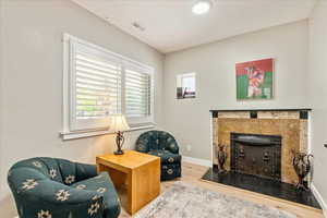 Sitting room with wood finished floors and a tile fireplace