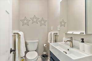 Half bathroom with vanity and toilet