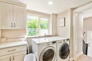 Laundry area with washing machine and dryer and light wood finished floors