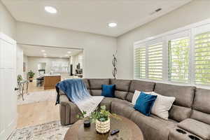 Living area featuring light wood finished floors and recessed lighting