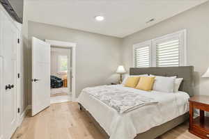 Bedroom with light wood finished floors and baseboards