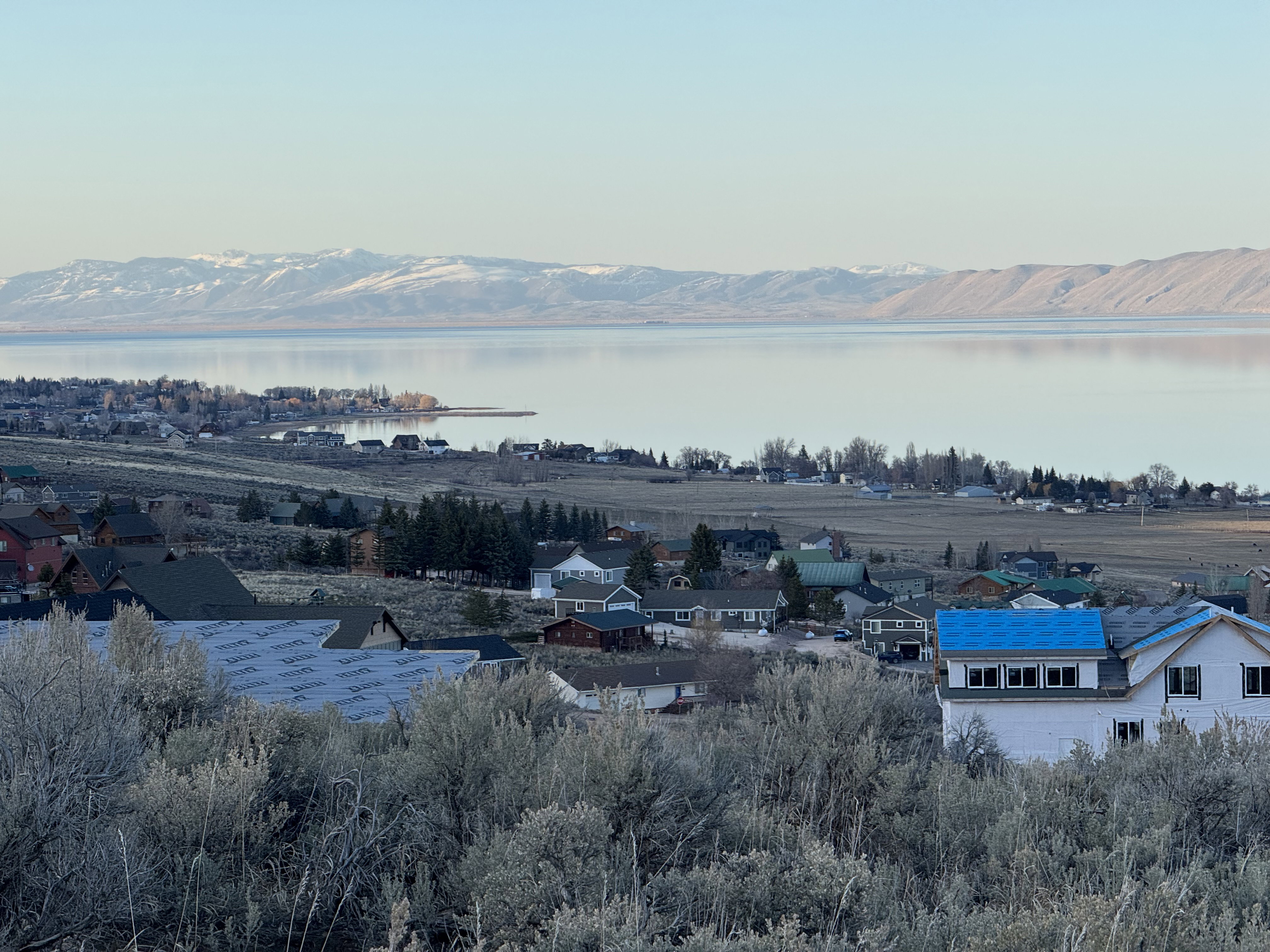 Aerial perspective of suburban area featuring a nearby body of water