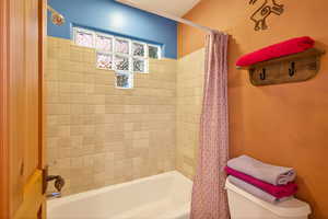 Bathroom featuring shower / bath combo and toilet