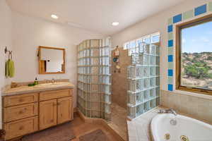 Bathroom featuring vanity, walk in shower, a jetted tub, light tile patterned flooring, and recessed lighting