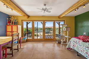 Bedroom with beamed ceiling, rail lighting, access to outside, light tile patterned floors, and ceiling fan