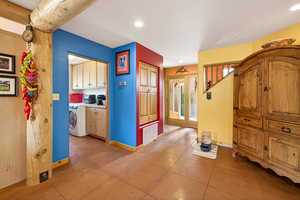 Kitchen with washer / clothes dryer, light tile patterned flooring, wood finish cabinetry, and recessed lighting