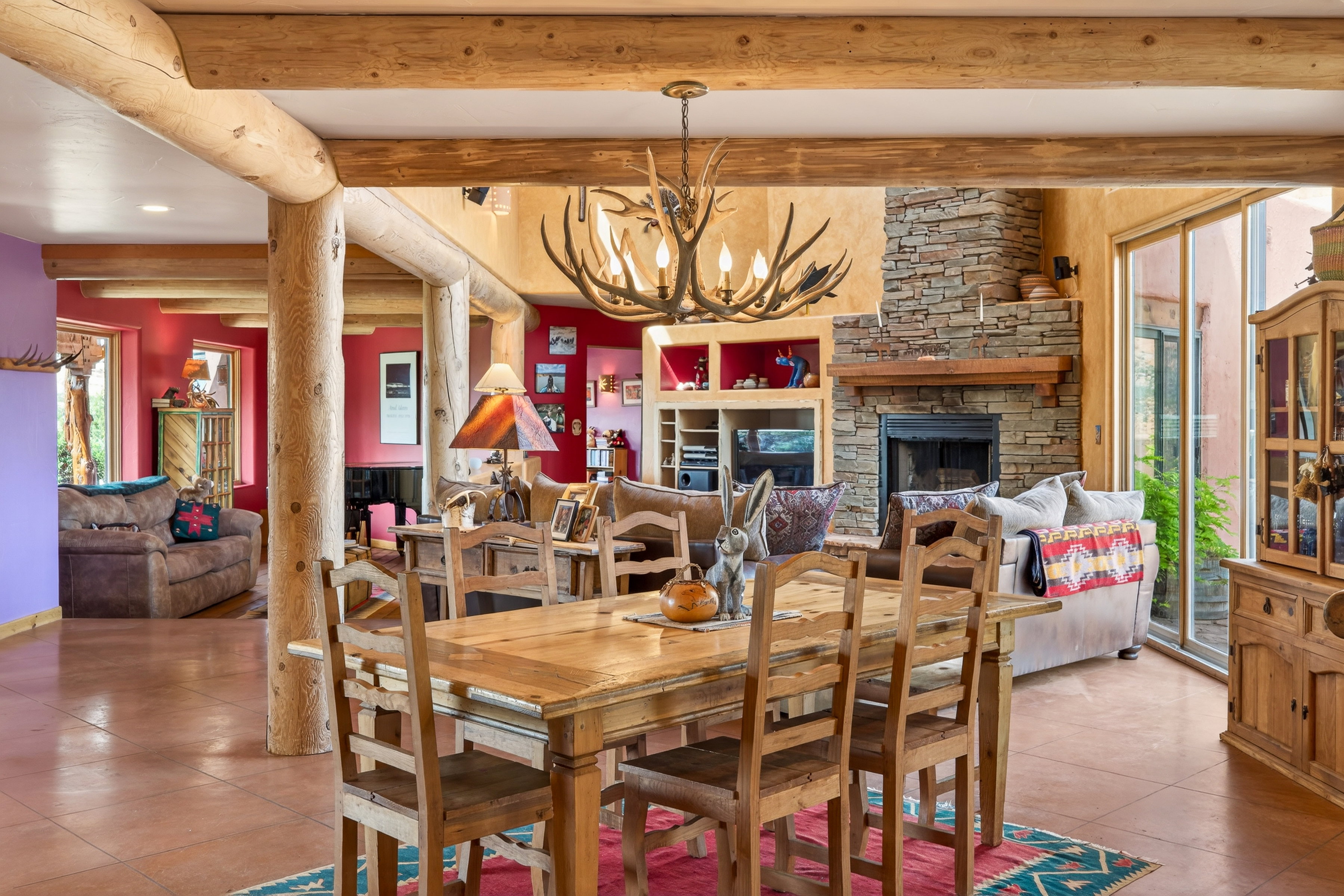 Tiled dining room featuring healthy amount of natural light, hanging lights, a fireplace, and beam ceiling