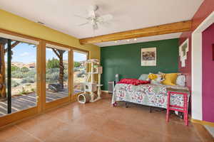 Bedroom featuring beamed ceiling, ceiling fan, access to outside, light tile patterned floors, and radiator heating unit