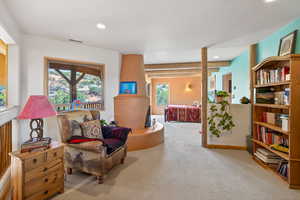 Sitting room with light colored carpet and recessed lighting