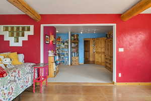 Bedroom with beam ceiling and tile patterned flooring