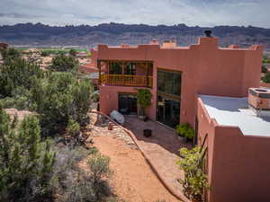 Back of house featuring a mountain view and stucco siding