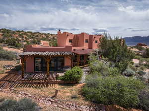 Rear view of house featuring stucco siding, a pergola, and a mountain view
