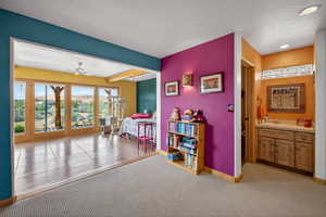 Recreation room featuring light colored carpet and ceiling fan