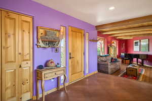 Living area featuring beam ceiling and recessed lighting